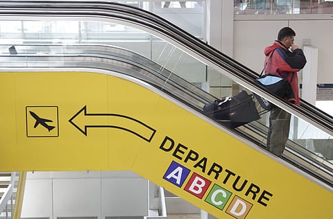A passenger is seen on an escalator at Cointrin airport in Geneva.