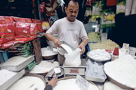 A shopkeeper measures out a quantity of sugar at the wholesale market of old Delhi. The Indian economy contracted by 23.9% year-on-year.