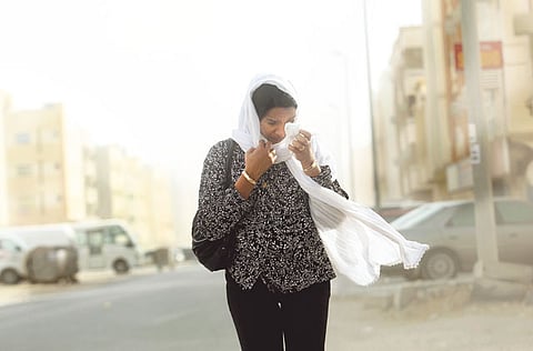 A woman covers her face during a sandstorm in Dubai. According to the met office, the weather could lead to reduced visibility.