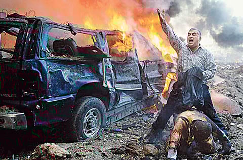 A man shouts for help for a wounded man after the car bomb explosion in Beirut on
February 14, 2005, which killed Lebanon’s former prime minister Rafik Hariri. Lebanon will fund a UN-backed court that has charged Hezbollah operatives with the 2005 murder of ex-premier Rafiq Hariri, Prime Minister Najib Mikati said in comments published Friday, September 2, 2011