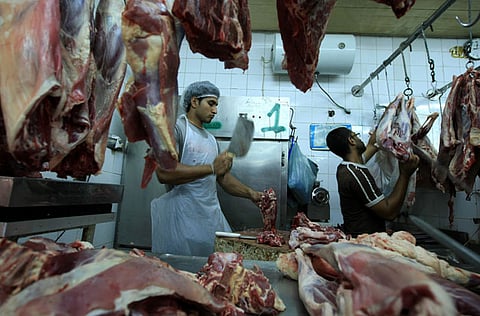 Butchers chop up meat at a butcher shop. For illustrative purposes only.