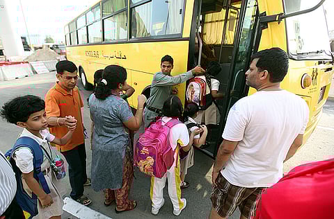 Parents assist their children in boarding a school bus in Dubai. For illustrative purposes only.