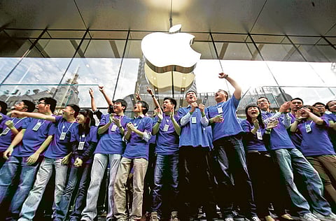 File picture of employees cheering the opening of a new Apple Store in Shanghai. But the cheering has died down with Apple announcing the shot down of all stores.
