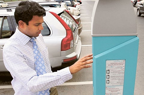 File photo of a motorist using a parking metre in Abu Dhabi. Photo for illustrative purposes only.
