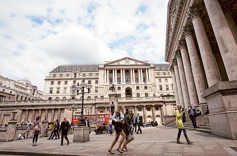 Pedestrians are seen outside the Bank of England. Ratings agency Moody’s cut the United Kingdom’s debt rating on Friday over the huge economic hit from the coronavirus crisis, Brexit and the lack of clear budget plans.