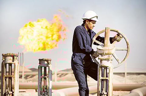 A worker adjusts the valve of an oil pipe at West Qurna oilfield in Iraq’s southern province of Basra.Oil prices rose 2 per cent on Tuesday, reaching their highest in 12 months.
