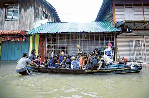 Villagers help flood victims in Rantau Panjang, a Malaysian town bordering Thailand.