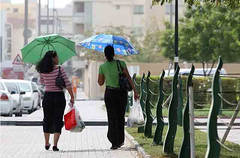 Pedestrians shelters from the sun in Dubai.