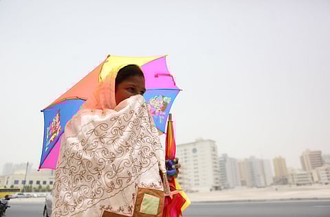 A woman braves the windy and dusty weather in Dubai.