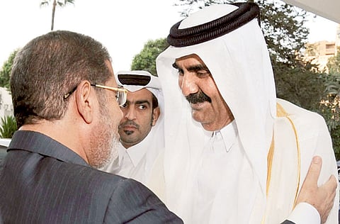 This file 2012 picture shows Egypt's then President Mohammad Mursi of the Muslim Brotherhood greeting Qatar's then Emir Shaikh Hamad Bin Khalifa.