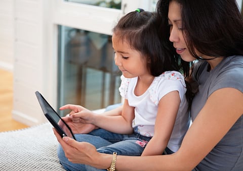 Mother and daughter reading stories on an iPad