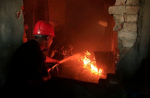 A Pakistani fireman tries to extinguish a factory fire in Lahore, Pakistan.