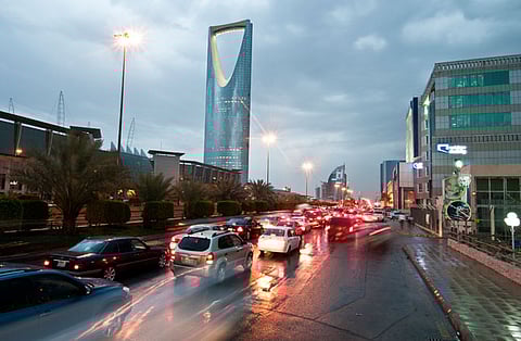 Traffic passes the Kingdom Tower, left, on King Fahad Road in Riyadh, Saudi Arabia.