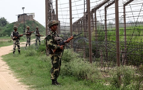 In this photograph taken on August 2, 2012 Indian Border Security Force (BSF) soldiers stand guard along fencing near the India-Pakistan Chachwal border outpost, some 65 kms north from the north-eastern Indian city of Jammu.