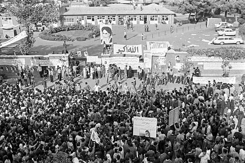 In this Nov. 13, 1979 photo, Iranians pray and gather in front of the American Embassy in Tehran, Iran, where Islamic "revolutionary" students had been holding 60 American employees hostage since Nov. 4, 1979.