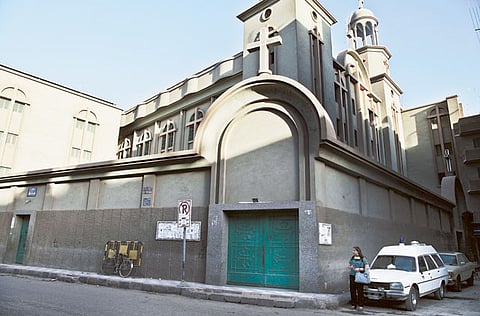 A woman stands in front of a church in Assiut. Picture for illustrative purposes only.