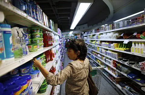 A woman looks at a product as she pushes a cart down an aisle in a supermarket in Caracas. Supplies of food and other basic products have been patchy in recent months, with long queues forming at supermarkets and rushes occurring when there is news of a new stock arrival. The situation has spawned jokes among Venezuelans, particularly over the lack of toilet paper.