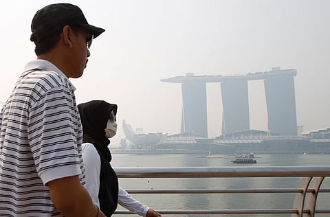 File picture of a tourist passing the Marina Bay Sands casino and resort in Singapore.