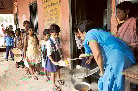 Indian schoolchildren receive a free meal at a school in Patna in a file picture. In the last financial year, only 11 per cent of parents bought books from the government aid credited to their accounts, while in 2019-20, it was 19 per cent.