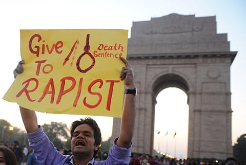 (FILE) In this photograph taken on December 19, 2012, Indian students and activists carry placards at India Gate in New Delhi, during a protest following the gang-rape of a student in the Indian capital. An Indian court found a teenager guilty August 31, 2013 over the fatal gang-rape of a student in New Delhi, a crime that sparked revulsion and angry protests in the country, an official said.