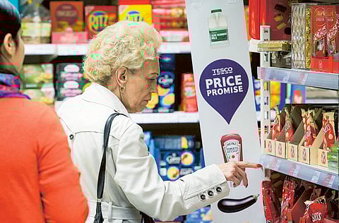 A customer browses for chocolates in a Tesco Metro store. UK households are heading into the “year of the squeeze” as surging energy bills and faster inflation eat into incomes.