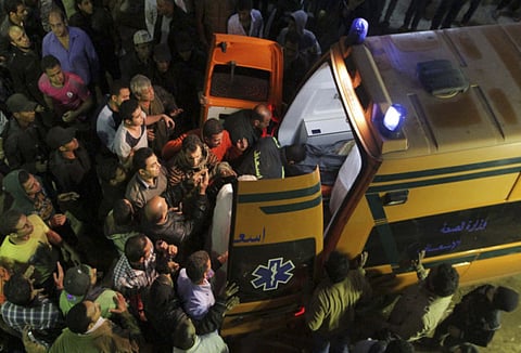 A file picture of people and rescue workers carry a body which was removed from the site of a collapsed eight-storey building into an ambulance, in the Cairo suburb of Matariya.