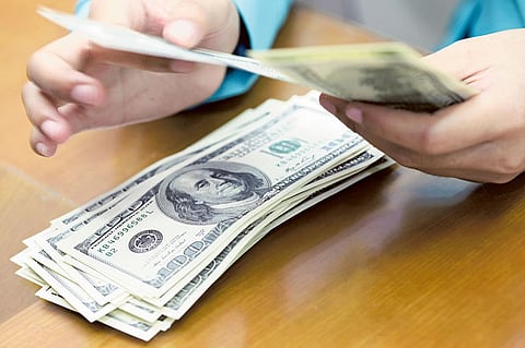A woman counts US dollar at a money changer in Jakarta, Indonesia
