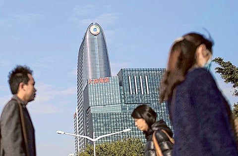 Commuters walk past the Tencent building in the Nanshan district of Shenzhen, China