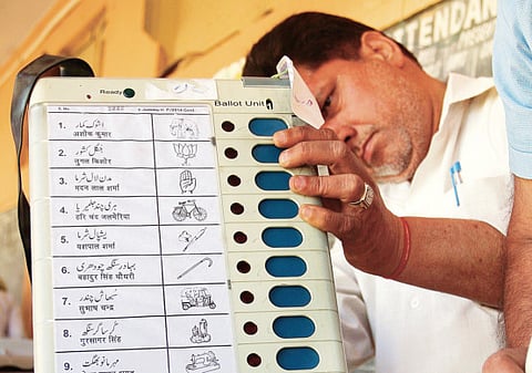 In this file photo, an Indian official examines an electronic voting machine (EVM). The dates for polling in five states have been announced.