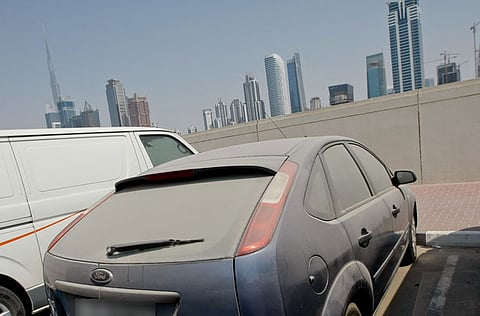 Cars collecting dust on a street in Dubai