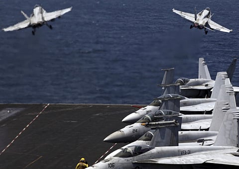 FILE - In this Monday, Aug. 11, 2014 file photo, F/A-18 fighter jets take off for mission in Iraq from the flight deck of the U.S. Navy aircraft carrier USS George H.W. Bush, in the Arabian Gulf.
