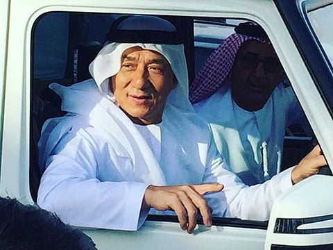 Here's Jackie Chan — in a kandura with camels
