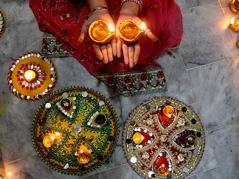 A Pakistani Hindu woman lights candles during Diwali celebrations at a local temple in Lahore, Pakistan