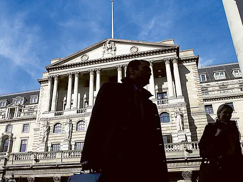 Pedestrians walk past the Bank of England in London.