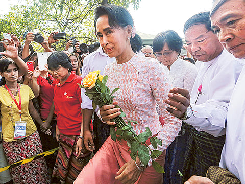 Aung San Suu Kyi is
mobbed by supporters
in Rangoon on Monday as
election results unfolded.