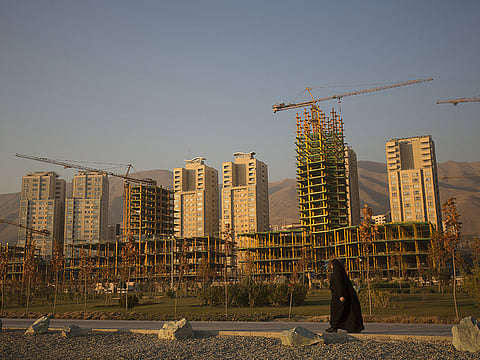 Iran's economy is tanking as US sanctions bite into growth chances. File picture of a pedestrian passing by a construction site in Tehran.