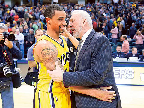 Gregg Popovich, head coach of the San Antonio Spurs, talks to a former player George Hill #3 of the Pacers.