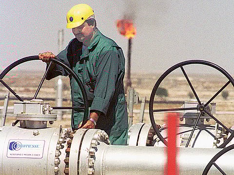 A worker of Kuwait Oil Company adjusts the flow of crude oil into a gathering centre. The cost of oil extraction is relatively less for the UAE, Saudi Arabia and Kuwait, where it is below the $16 per barrel mark.