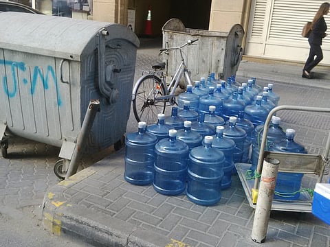Water bottles placed next to garbage bin