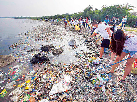 File photo: Volunteers collect garbage along the shore off Manila Bay.