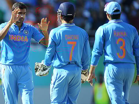 Ravichandran Ashwin (left) is congratulated by teammates M.S. Dhoni and Suresh Raina (right) during their 2015 ICC World Cup campaign in Australia.