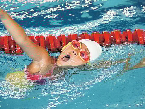 A young child at a swimming pool.
