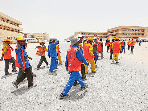 Workers make their way back to their accommodation in Muhaisnah, Dubai .