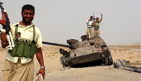 Southern Resistance fighters with a tank destroyed during fighting against Al Houthi militiamen on outskirts of Yemen’s southern port city of Aden.