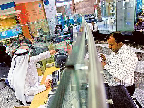 A customer at a bank counter in Dubai. The UAE Central Bank’s decision to support the UAE banking system through an extraordinary Dh100 billion stimulus package is expected to support the liquidity and solvency of UAE banks at a time the coronavirus outbreak and the impact from oil price collapse is expected to adversely impact both deposits and loan growth.