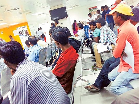 Indian expats at a BLS International centre in Abu Dhabi, the outsourced agency processing Indian passport and visa applications.