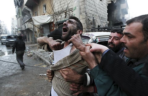 A father reacts after the death of two of his children, whom activists said were killed by shelling by forces loyal to Syria's President Bashar al-Assad, at al-Ansari area in Aleppo, Syria January 3, 2013.