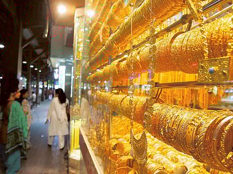 The wall of gold entices window shoppers at a store in Dubai. Jewellery retailers have started to fret as gold keeps pushing the $1,600 level.
