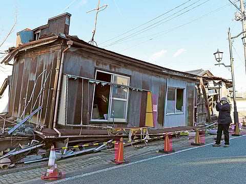A tourist looks at an abandoned house in Namie, Fukushima prefecture.