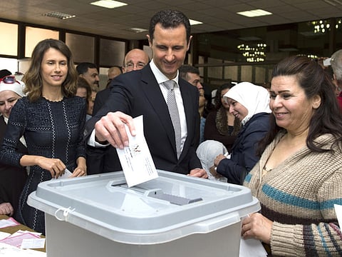 Bashar Al Assad and wife Asma (left) vote at a polling station in Damascus in the parliamentary elections